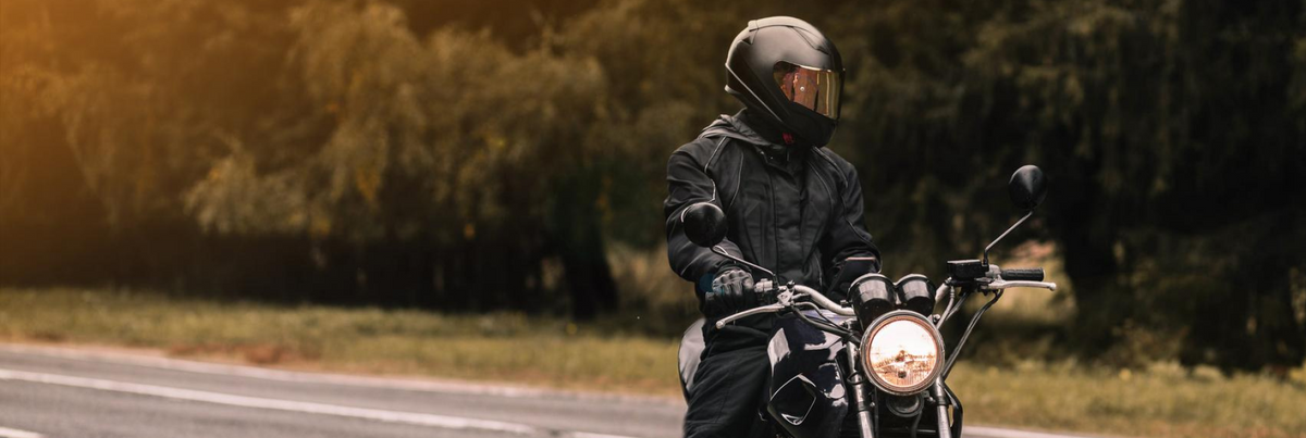 Motociclista in sella su strada di campagna